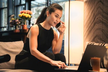 Business woman using a mobile phone and a laptop to work online. High quality photo