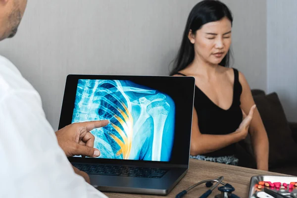 Doctor showing a x-ray of pain in the ribs of a woman patient. High quality photo