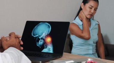 Doctor showing x-ray of pain in the neck on a laptop with woman patient. Migraine Headache illness. High quality 4k footage