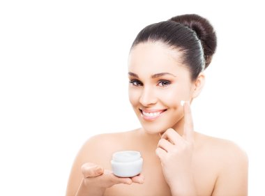 Smiling woman applying cosmetic cream clipart