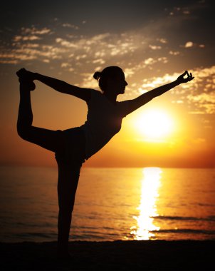 gün batımında yoga yaparken