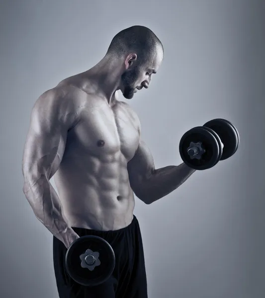 Treino de homem muscular com halteres — Fotografia de Stock