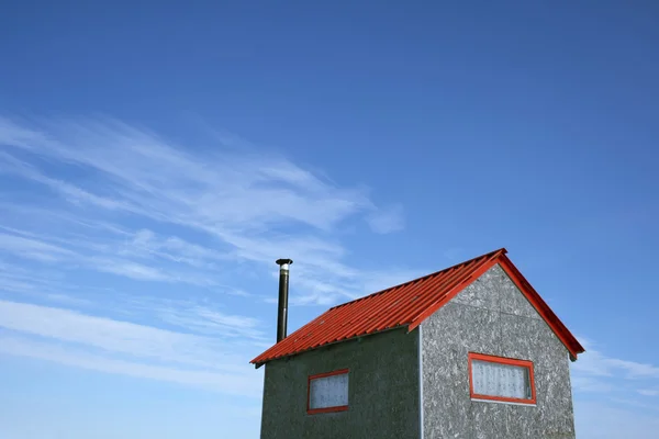 Malý domek a modrá obloha — Stock fotografie