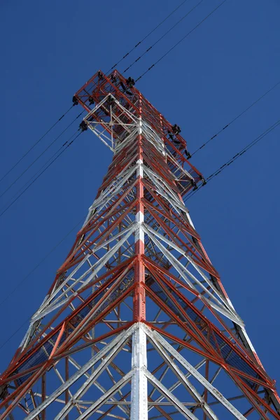 Pilón de electricidad rojo y blanco contra el cielo azul — Foto de Stock