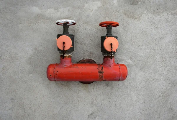 Válvula de hierro roja en una pared de hormigón — Foto de Stock