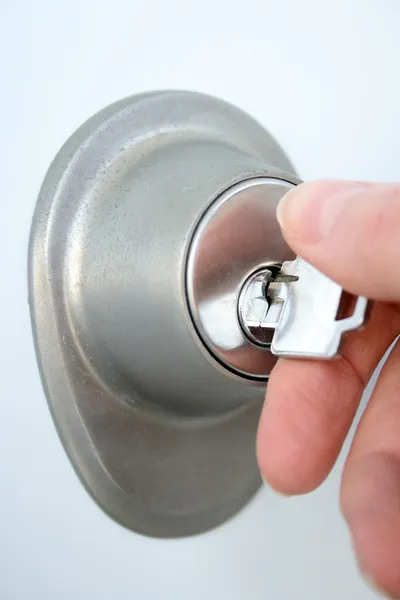 Mão destrancando a porta com uma chave — Fotografia de Stock
