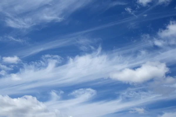 Lockige weiße Wolken am blauen Himmel — Stockfoto