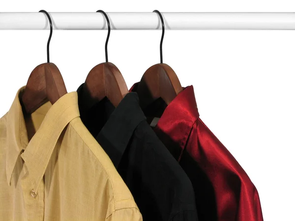 Kleurrijke shirts op hangers, op witte achtergrond — Stockfoto