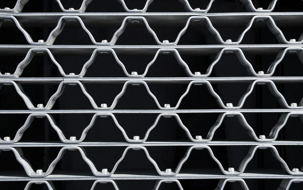 Golvenpatroon van een metalen raster — Stockfoto