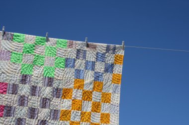 Patchwork counterpane on a clothes-line clipart