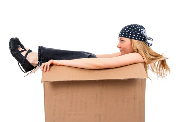 Menina sentada em uma caixa de papelão — Fotografia de Stock