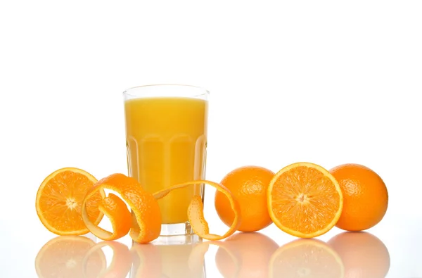 Glass of juice, oranges and orange peel — Stock Photo, Image