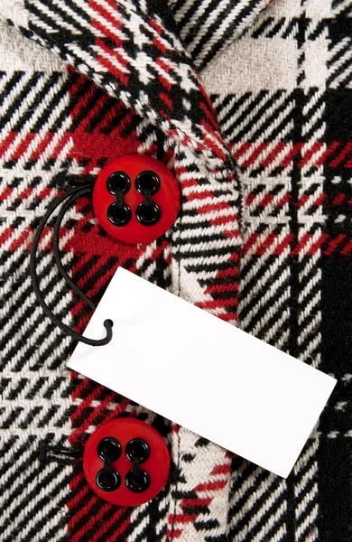 Etiqueta de preço em branco no casaco verificado com botões vermelhos — Fotografia de Stock