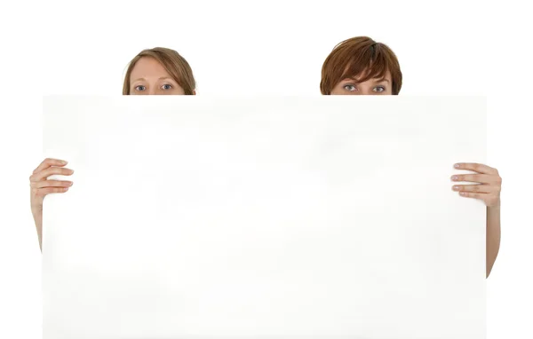 Two young women behind a blank banner ad — Stock Photo, Image