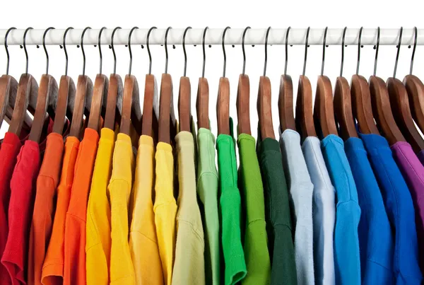 Rainbow colors, clothes on wooden hangers — Stock Photo, Image