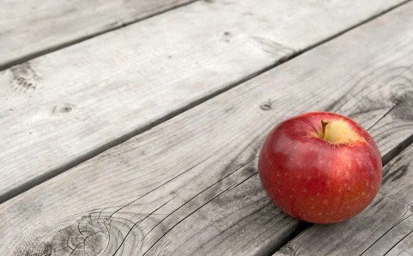 Rött äpple på gamla träbord — Stockfoto