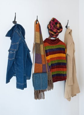 Colorful clothing on coat hooks clipart