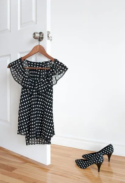 Puantiyeli bluz bir askı ve zemin üzerinde ayakkabı — Stok fotoğraf