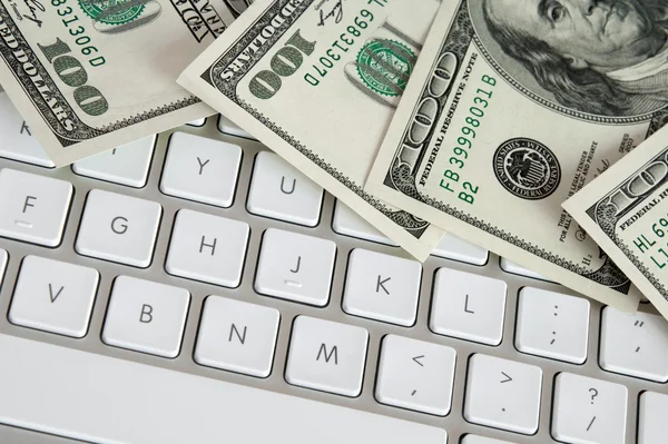 Billetes de cien dólares en el teclado del ordenador —  Fotos de Stock