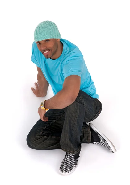 Relaxed young man in a blue t-shirt sitting on the floor — Stock Photo, Image