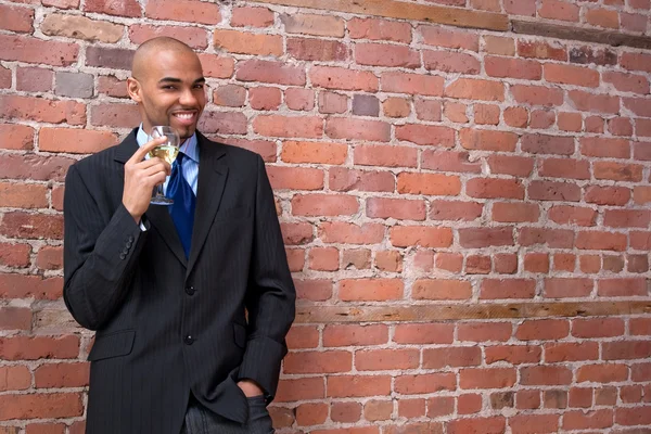 Young business man drinking wine and smiling