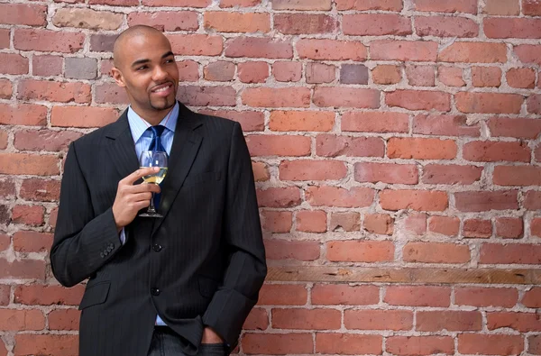 Sonriente joven hombre de negocios beber vino — Foto de Stock