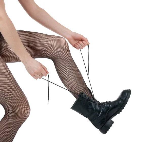Mädchen in Strumpfhosen schnürt ihre schwarzen Stiefel — Stockfoto