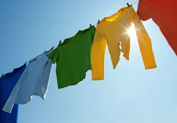 Bunte Kleidung an der Wäscheleine und Sonnenschein — Stockfoto