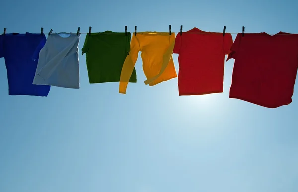 Słońce świeci przez kolorowe ubrania, suszenie na wietrze — Zdjęcie stockowe