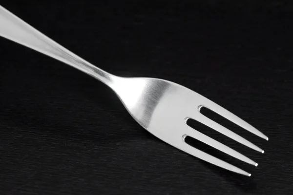 Glänsande silver gaffel på mörk trä bakgrund — Stockfoto