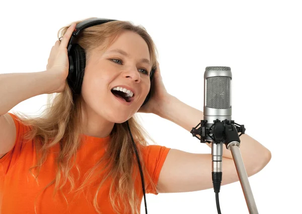 Young woman in orange t-shirt singing with the microphone — Stock Photo, Image