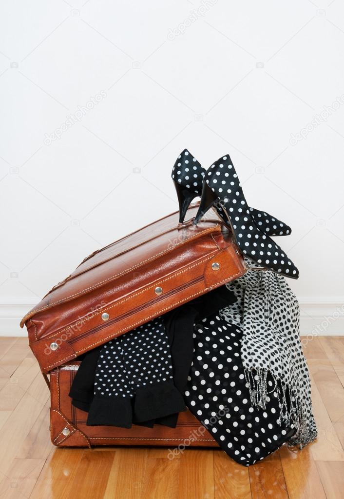 Polka dot clothing in a vintage leather suitcase