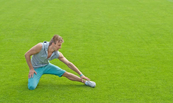 Young man exercising on sports field — Stock Photo, Image