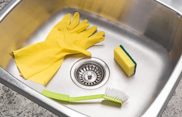 Guantes, esponja y cepillo en un fregadero de cocina limpio —  Fotos de Stock