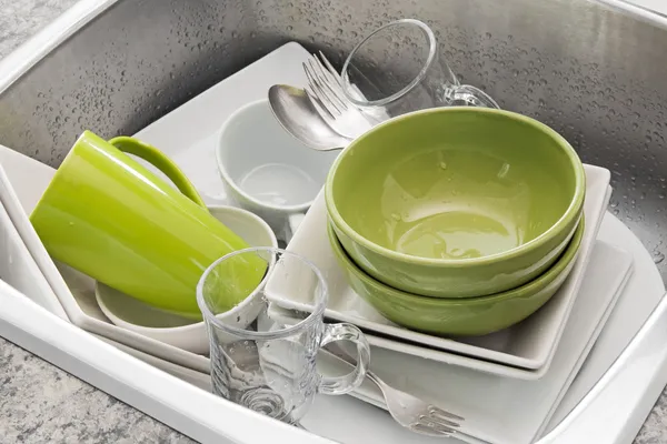 Washing dishes in the kitchen sink — Stock Photo, Image