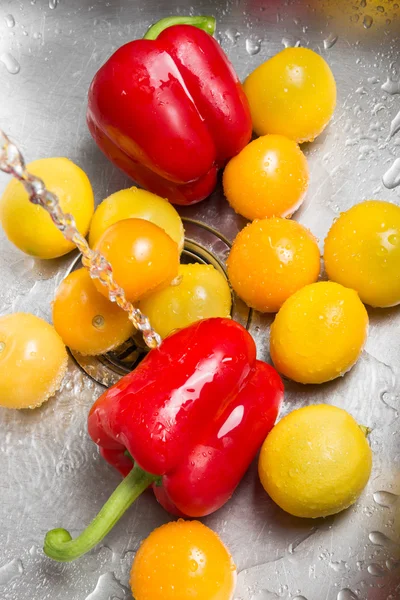 Стирка красных и желтых фруктов и овощей — стоковое фото