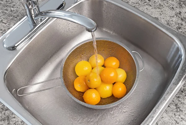 Washing yellow tomatoes — Stock Photo, Image