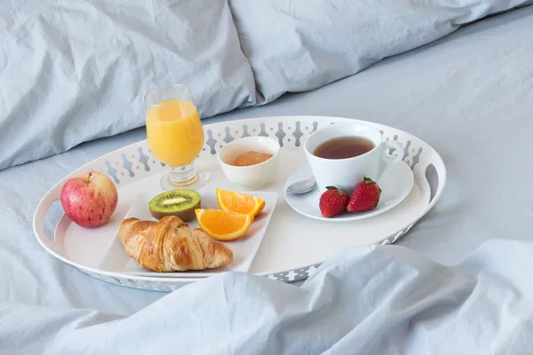 Yatağın üzerinde sağlıklı bir kahvaltı ile tepsi — Stok fotoğraf