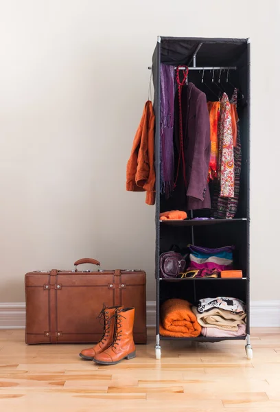 Mobile wardrobe with clothing and leather suitcase — Stock Photo, Image