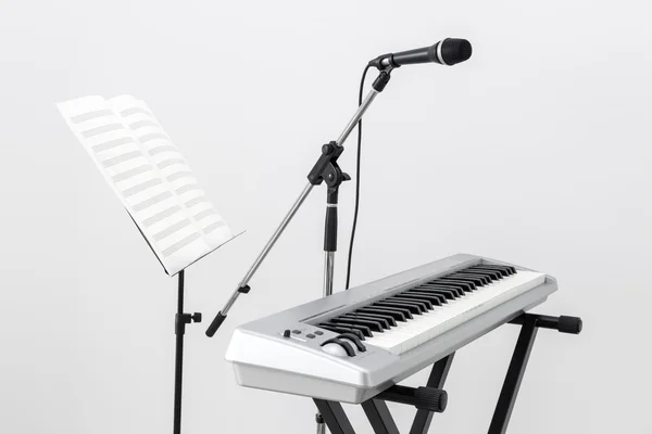 Piano elétrico, microfone e suporte de música — Fotografia de Stock