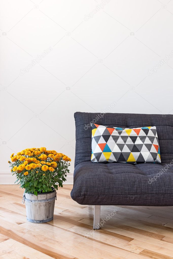 Orange chrysanthemums and sofa with bright cushion
