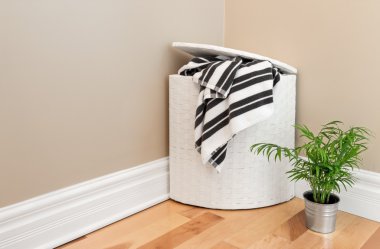 Wasmand en plant in de hoek van de kamer
