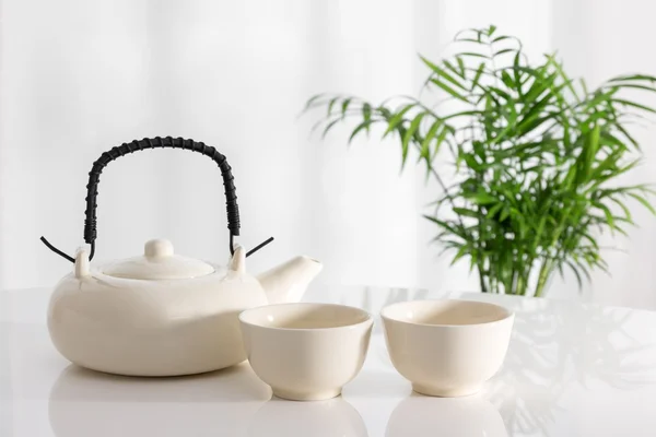Teiera in ceramica e tazze sul tavolo — Foto Stock