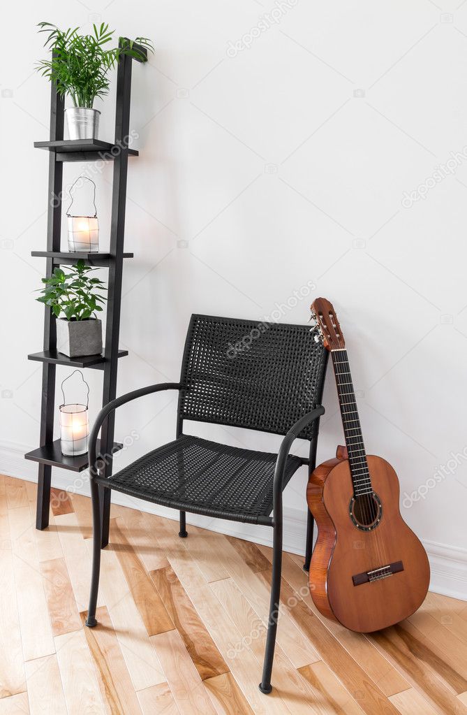 Room with simple furniture, plants and guitar