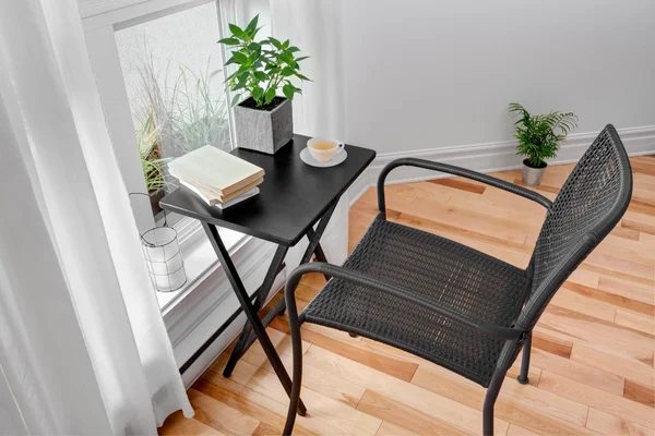 Стул и стол в комнате с зелеными растениями — стоковое фото