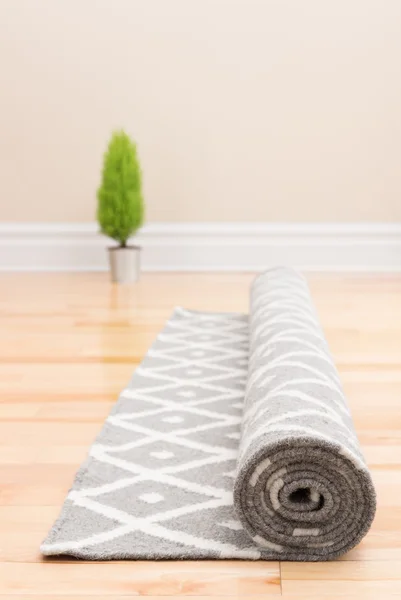 Unrolling carpet in a new home — Stock Photo, Image