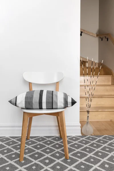 Chair with cushion in a room with staircase — Stock Photo, Image