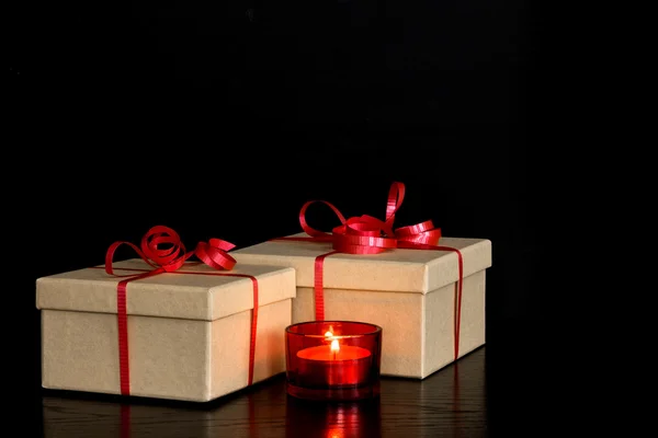Elegante Geschenke und rotes Kerzenlicht — Stockfoto
