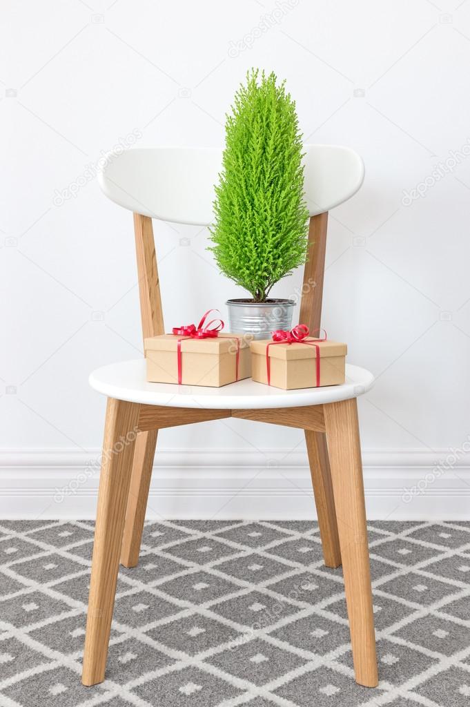 Presents and little green tree on a white chair