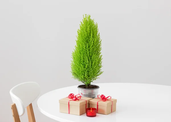 Weinig kerstboom en geschenken op een tafel — Stockfoto